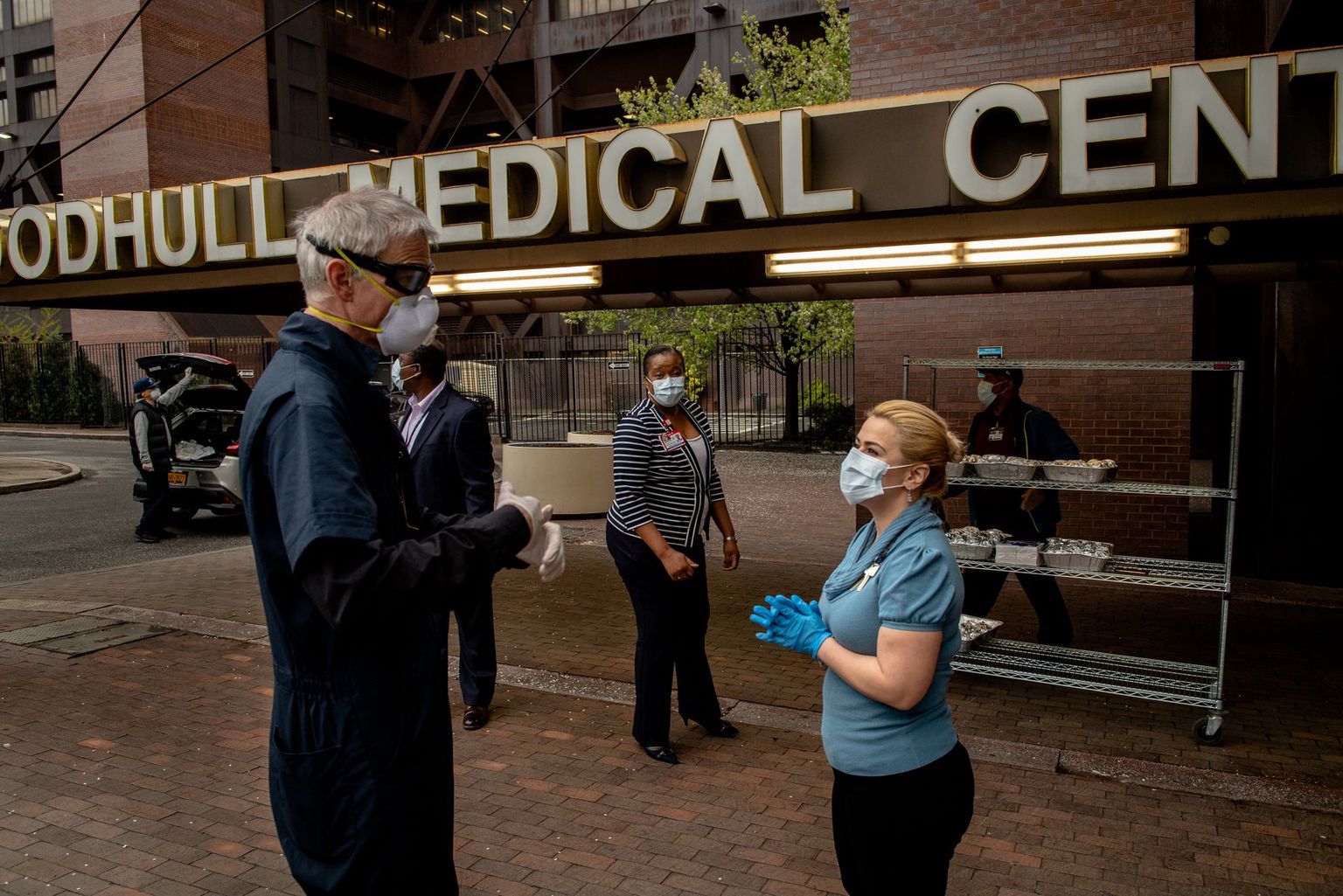 Father Merz dropping off meals with Angela Edwards, chief of nursing at Woodhull hospital. Photo Credit: Hilary Swift for The New York Times